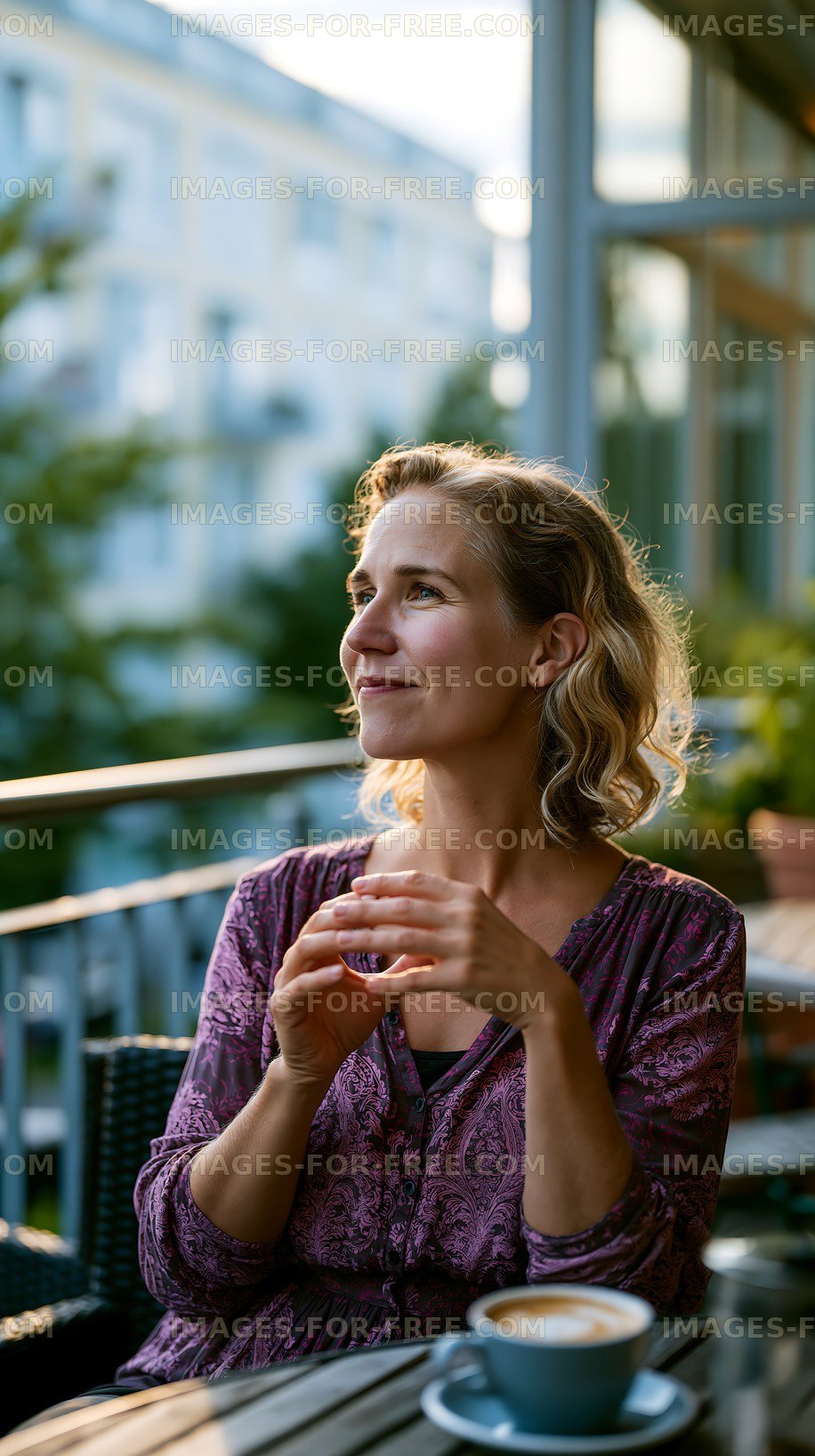 Woman enjoying a drink on a balcony during sunset