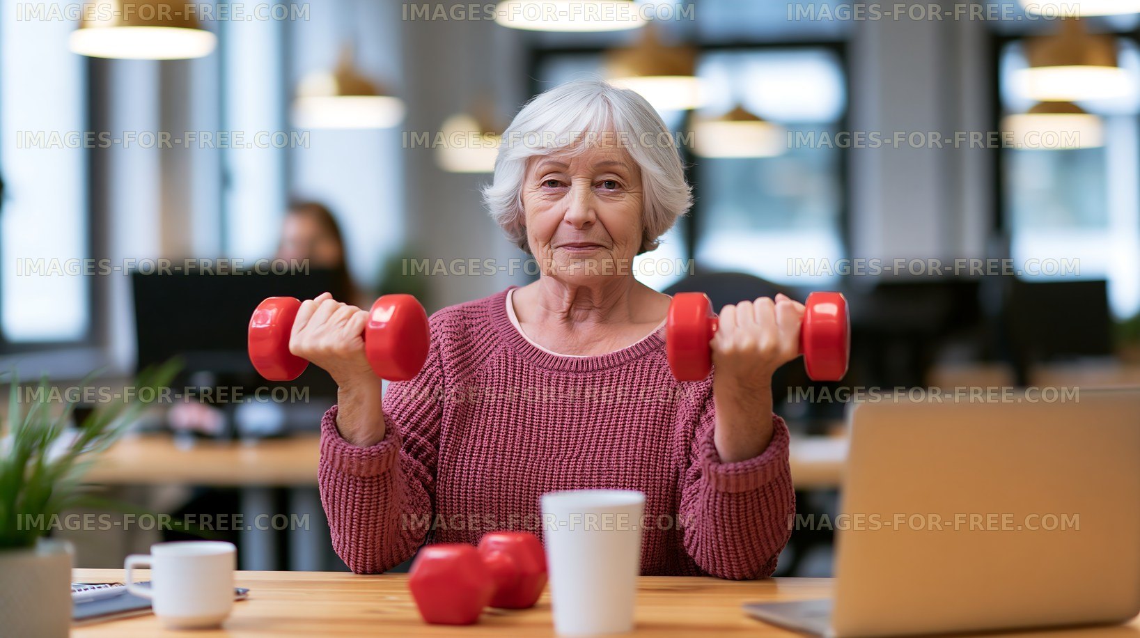 Senior woman with dumbbells in a modern office