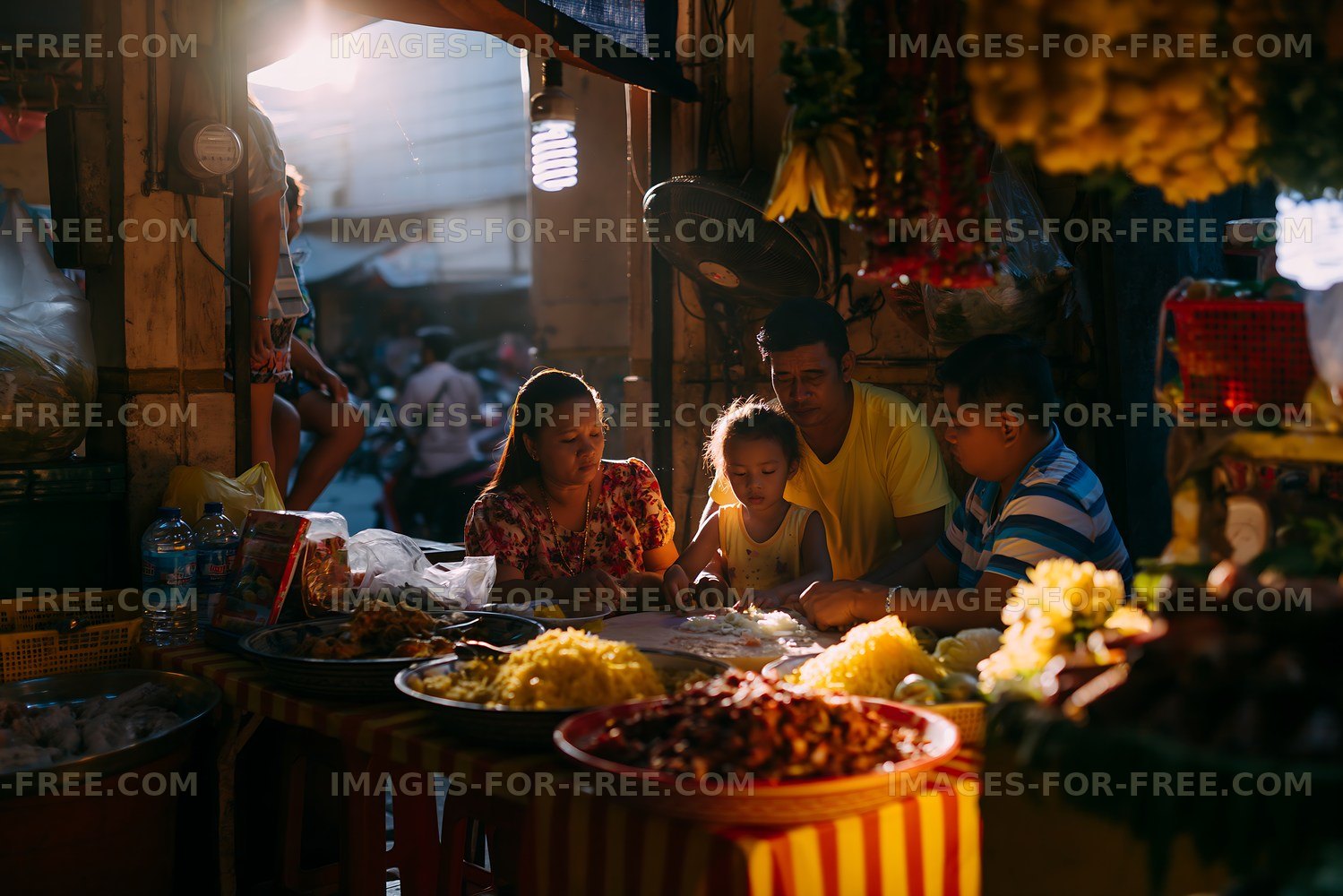 Family enjoying a meal at a street market in evening light