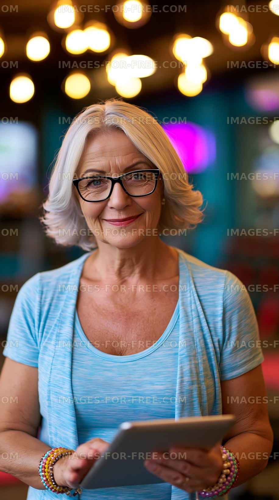 Smiling older woman with tablet in cafe setting