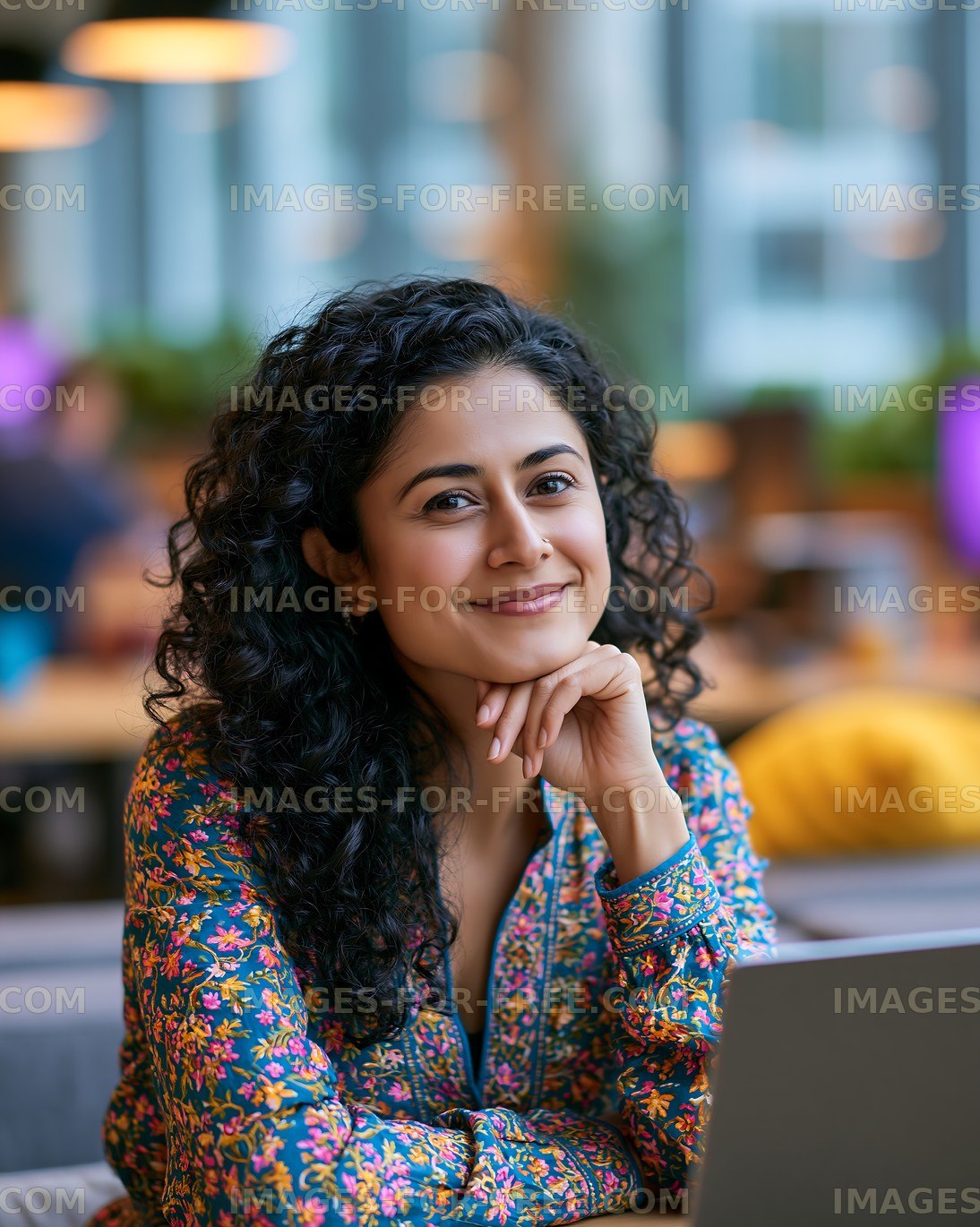 Smiling woman working on a laptop in a coffee shop