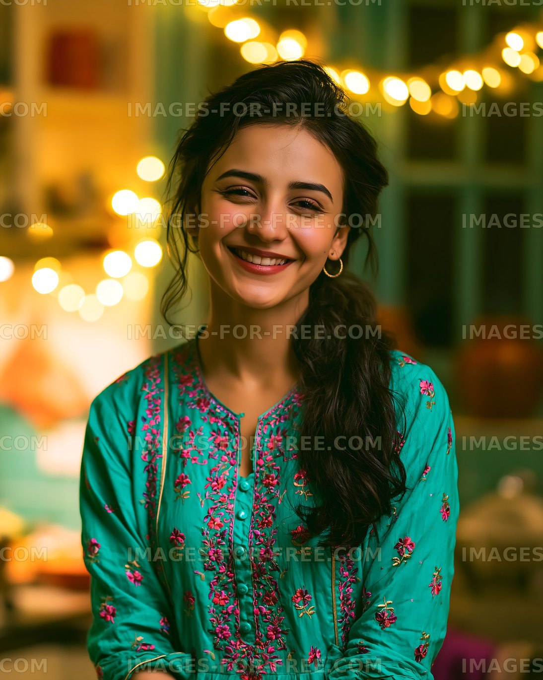 Woman smiling in traditional attire with fairy lights in background