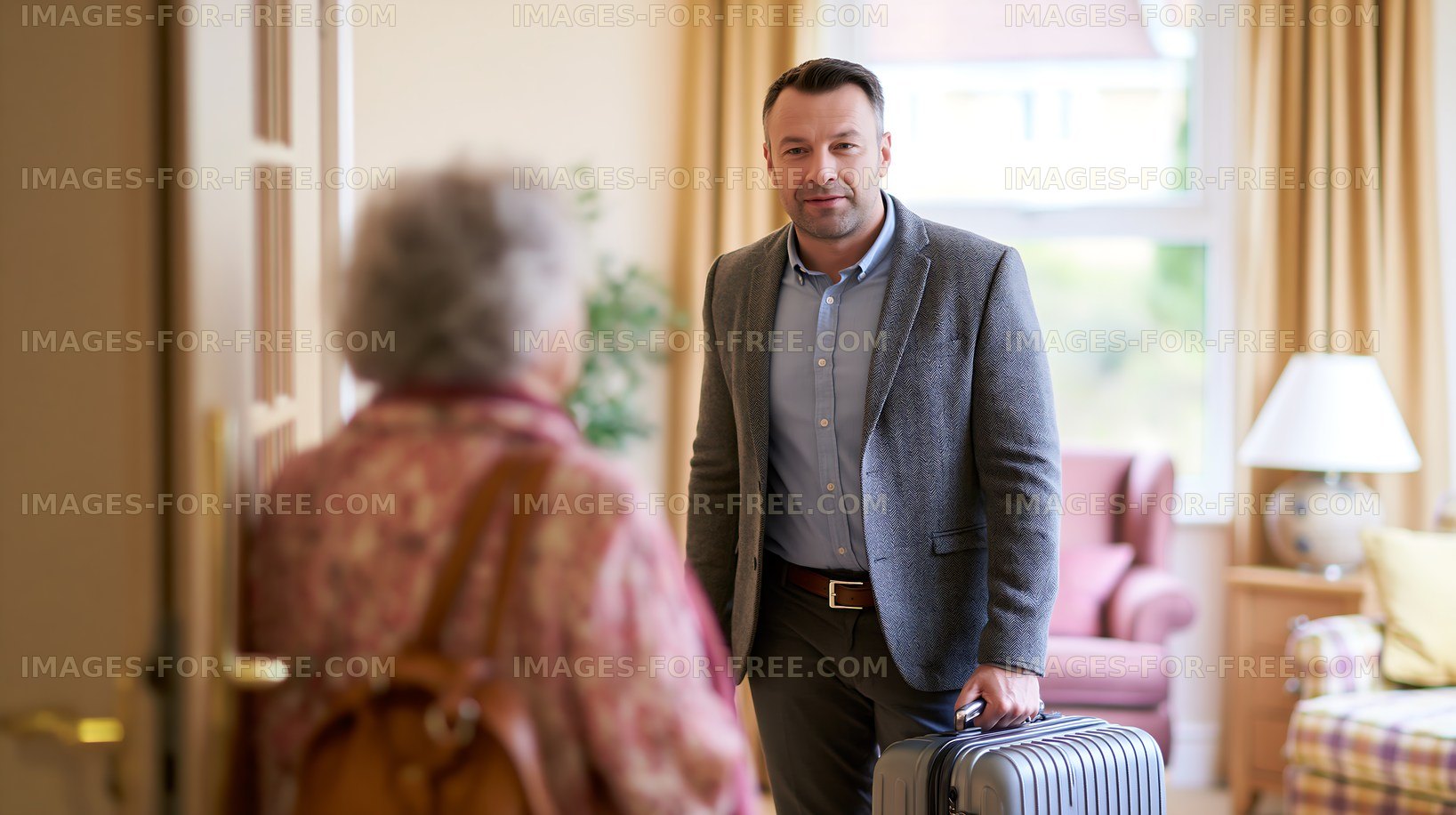 Man with suitcase greets elderly woman at home