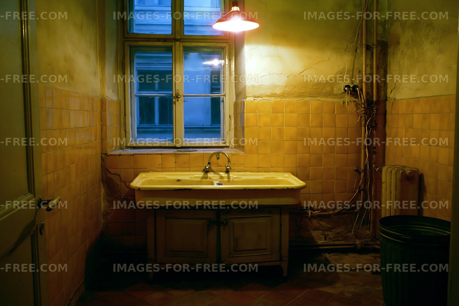 Old bathroom with yellow tiles and a single sink in low light