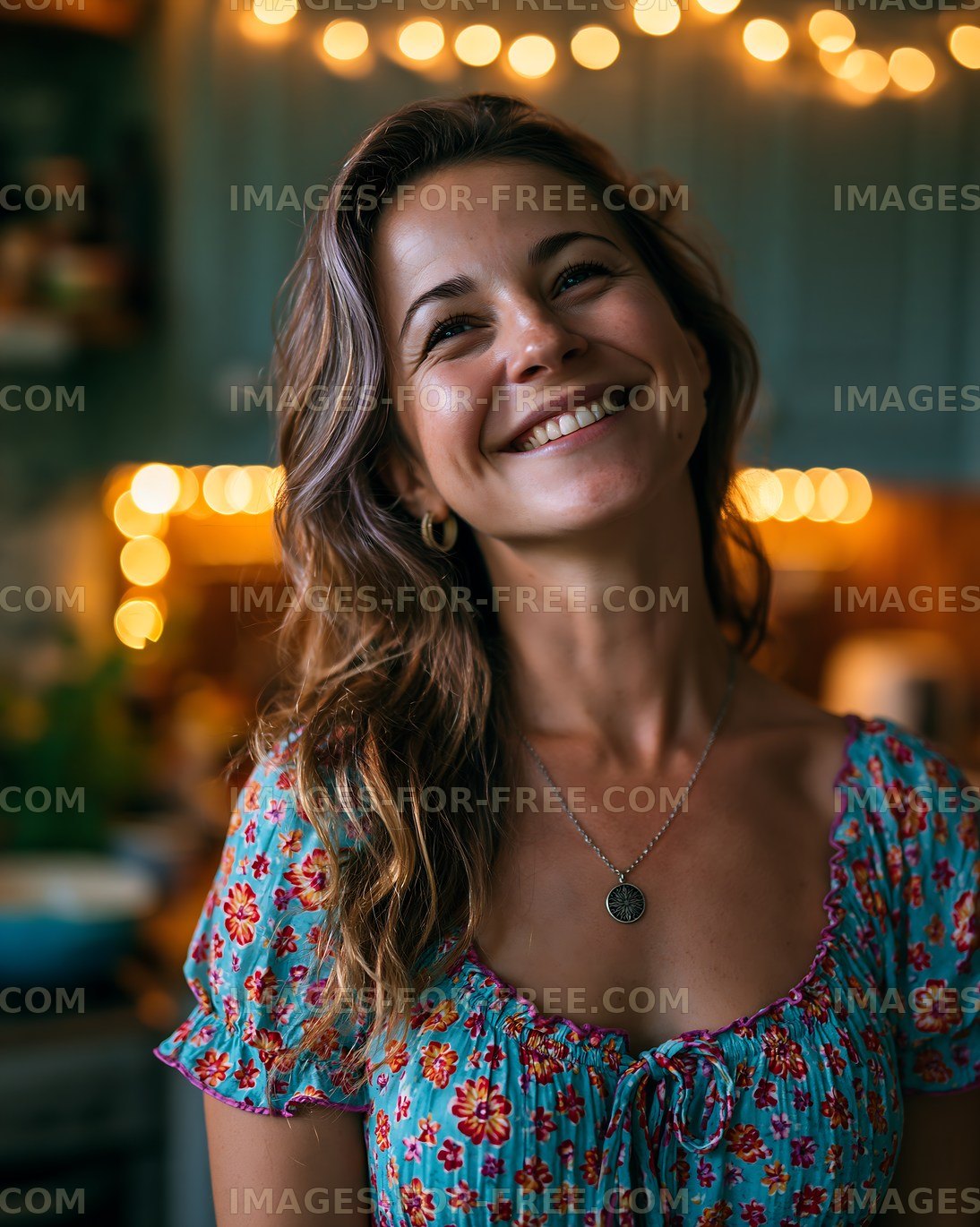 Smiling woman in a kitchen with string lights