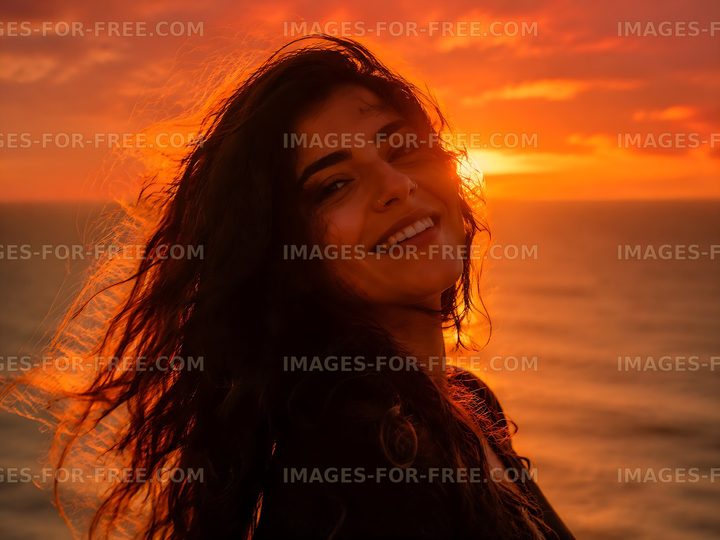 Smiling woman against sunset by the sea