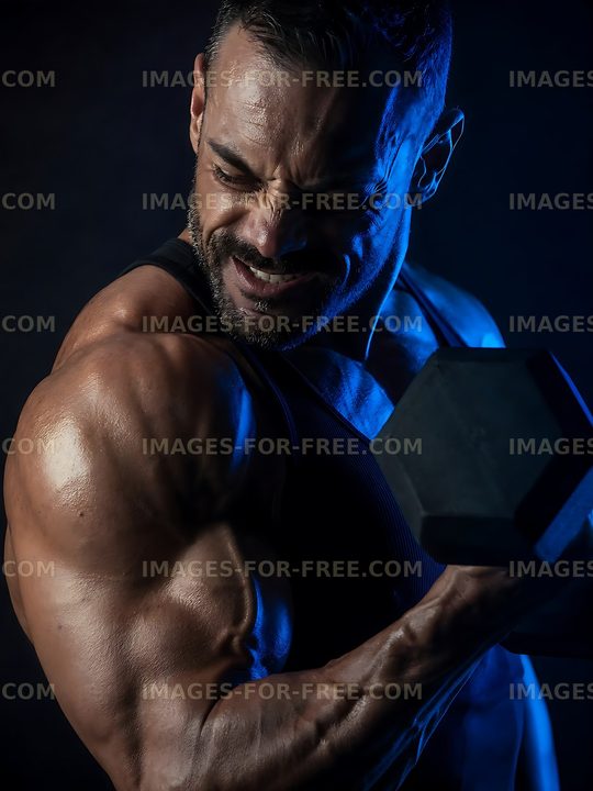 Muscular man lifting dumbbell in dimly lit gym